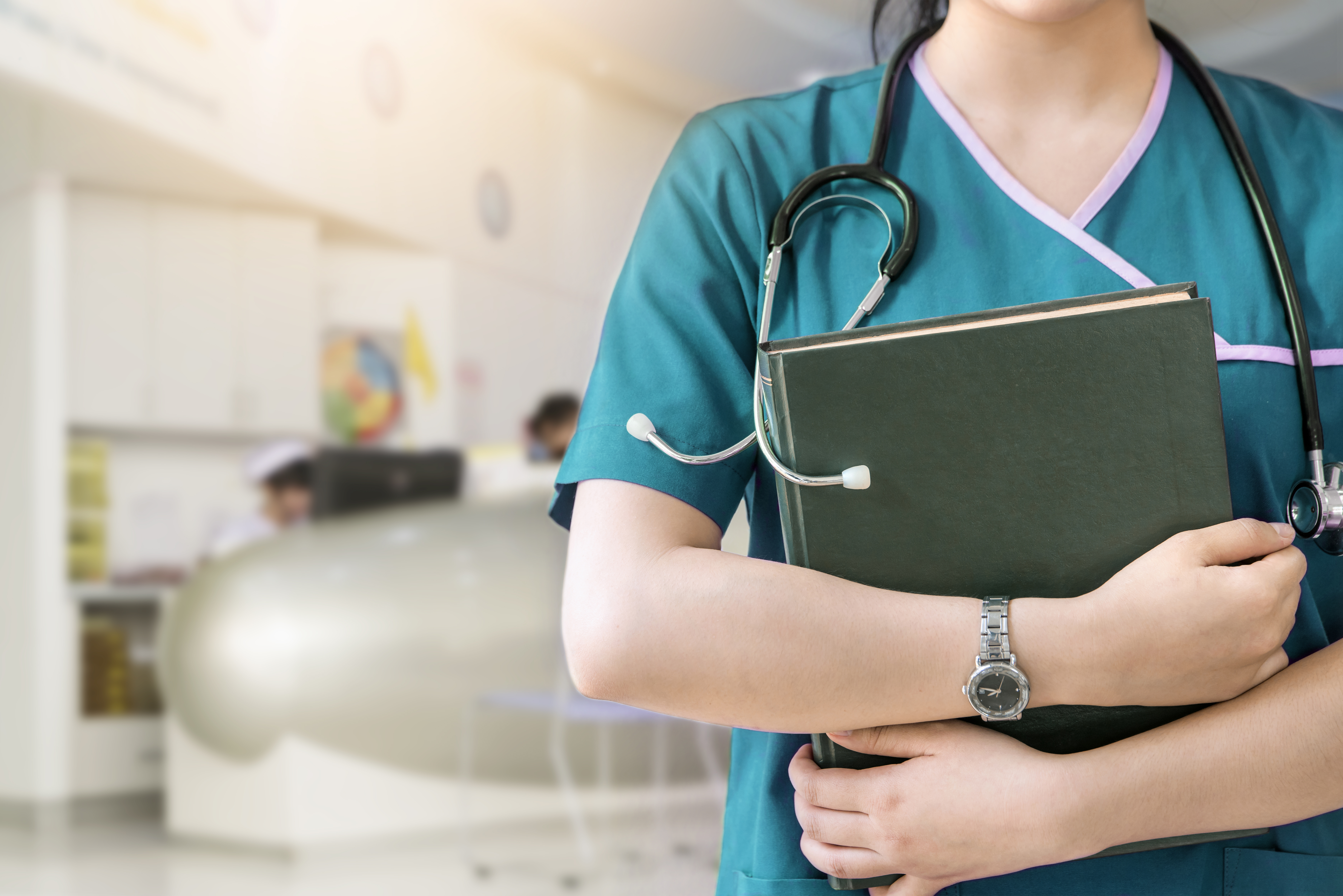 A partial image of a nursing student wearing scrubs and a stethoscope and holding a notebook.